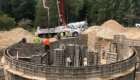 closer view of curved foundation and crew pouring cement