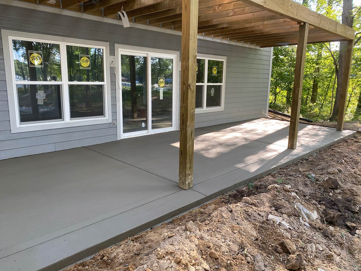 freshly poured concrete patio under deck