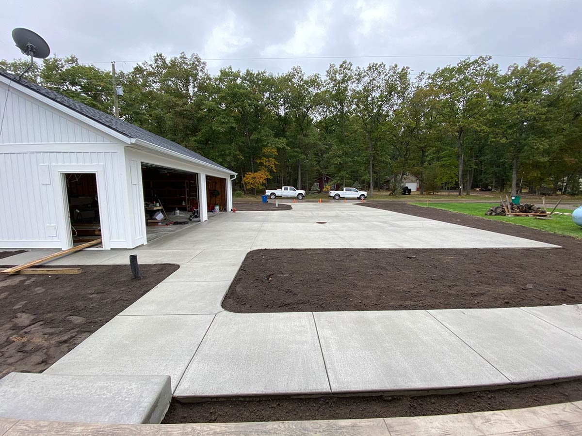 freshly poured concrete driveway and sidewalk at garage