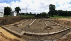 excavated job site with poured footings and trucks in background